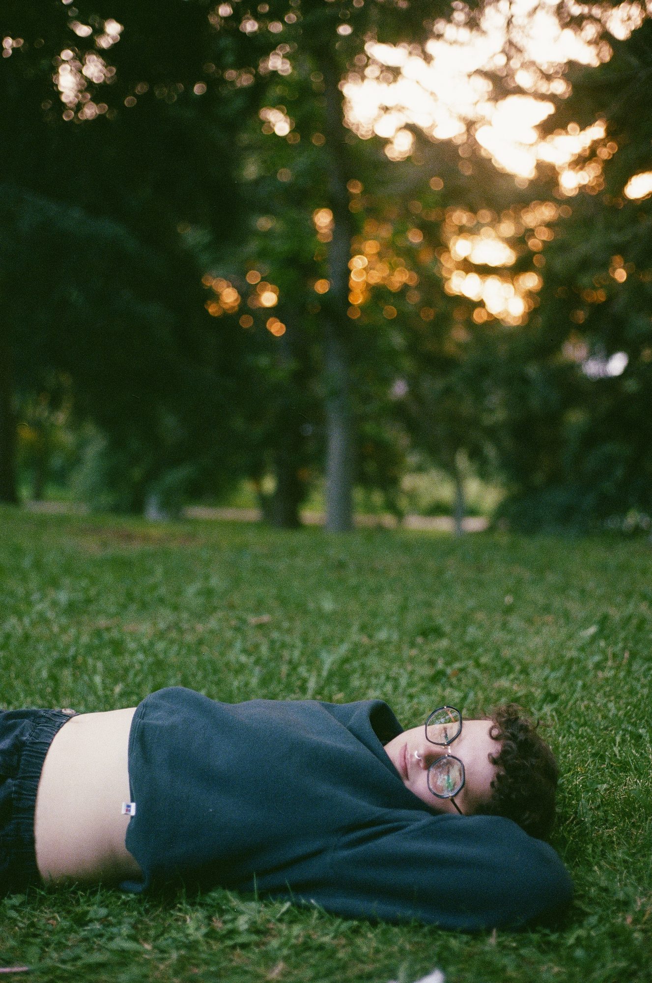 Person lying in the grass under evening light