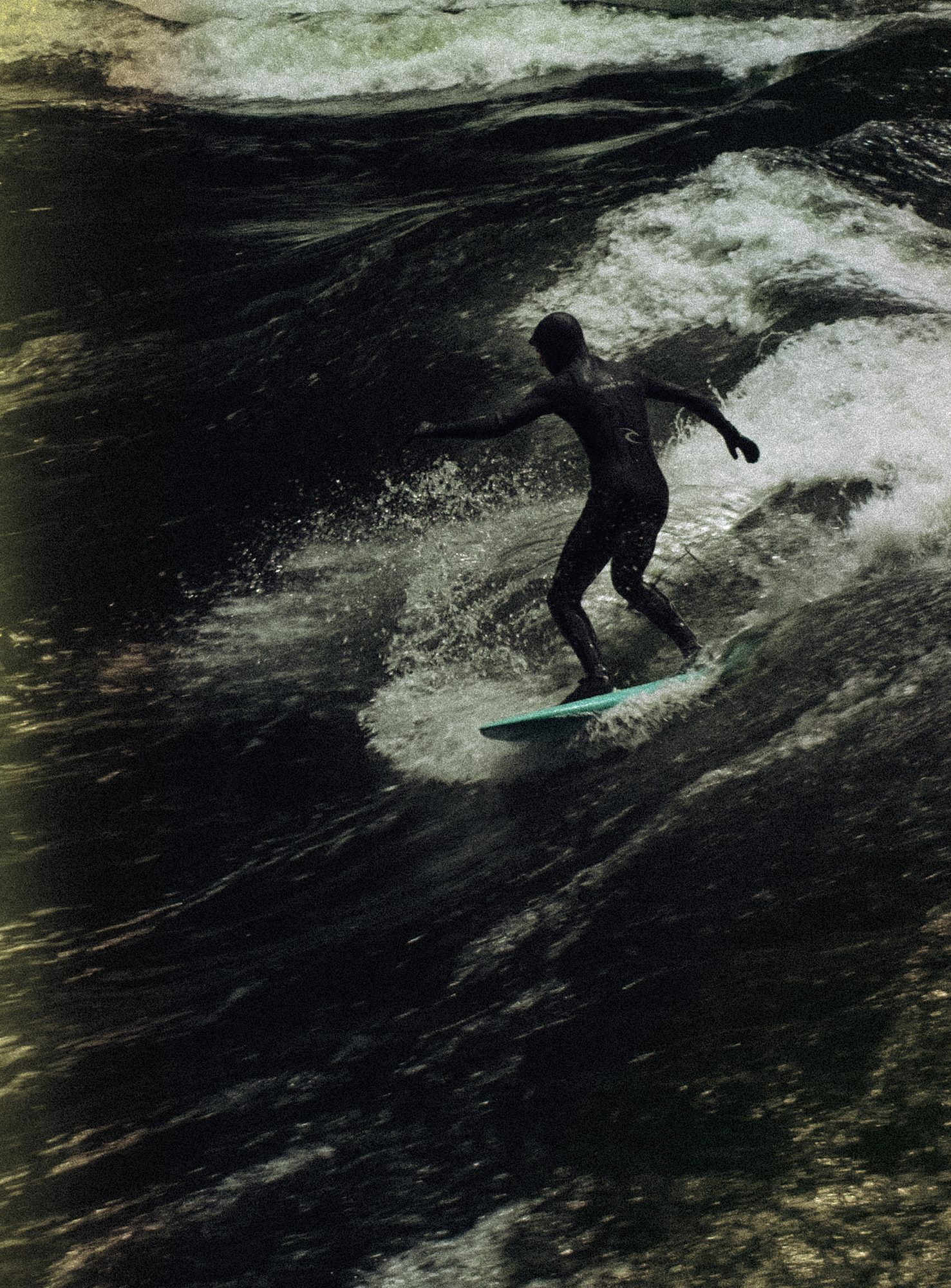 Silhouette of a surfer on a dark wave