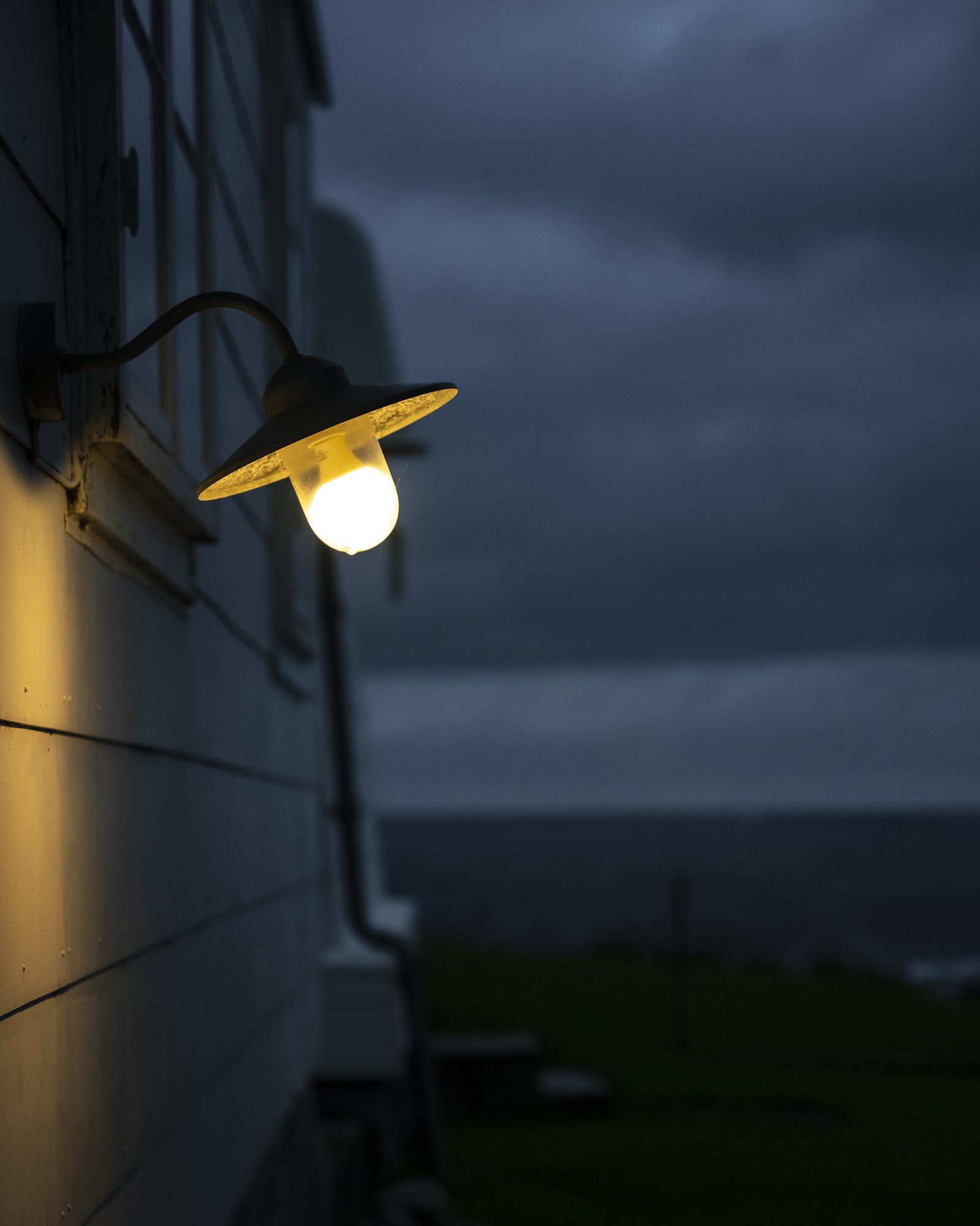 Lit wall lamp at dusk